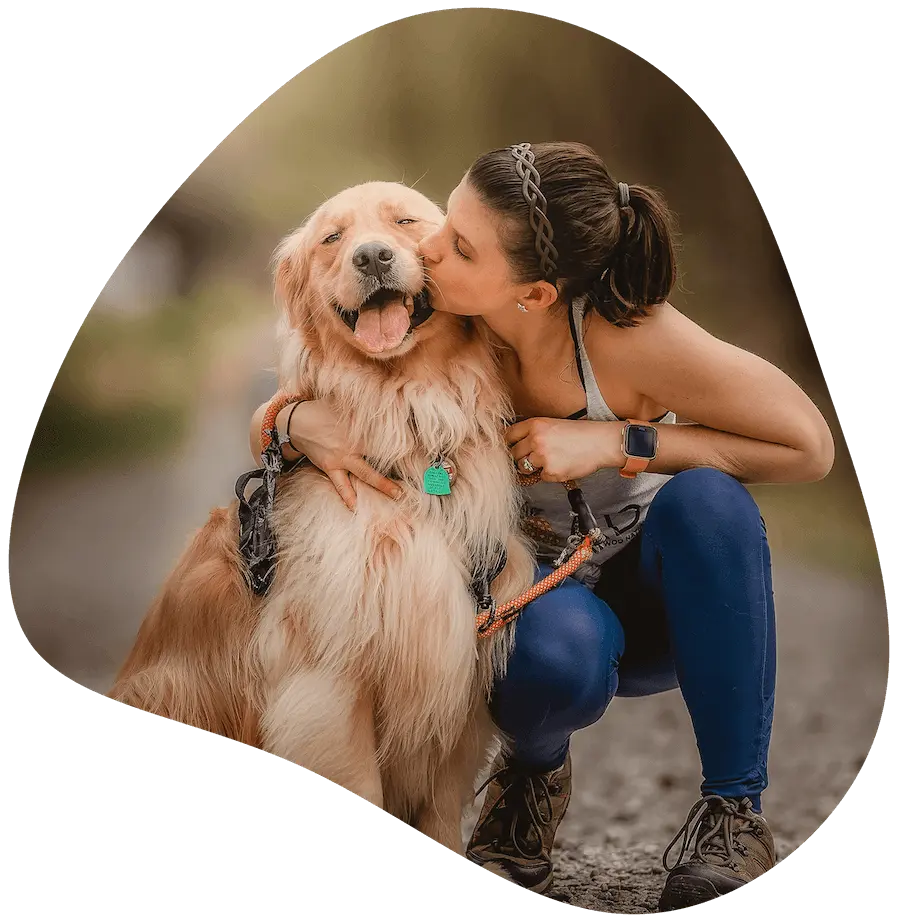 Woman kissing her golden retriever